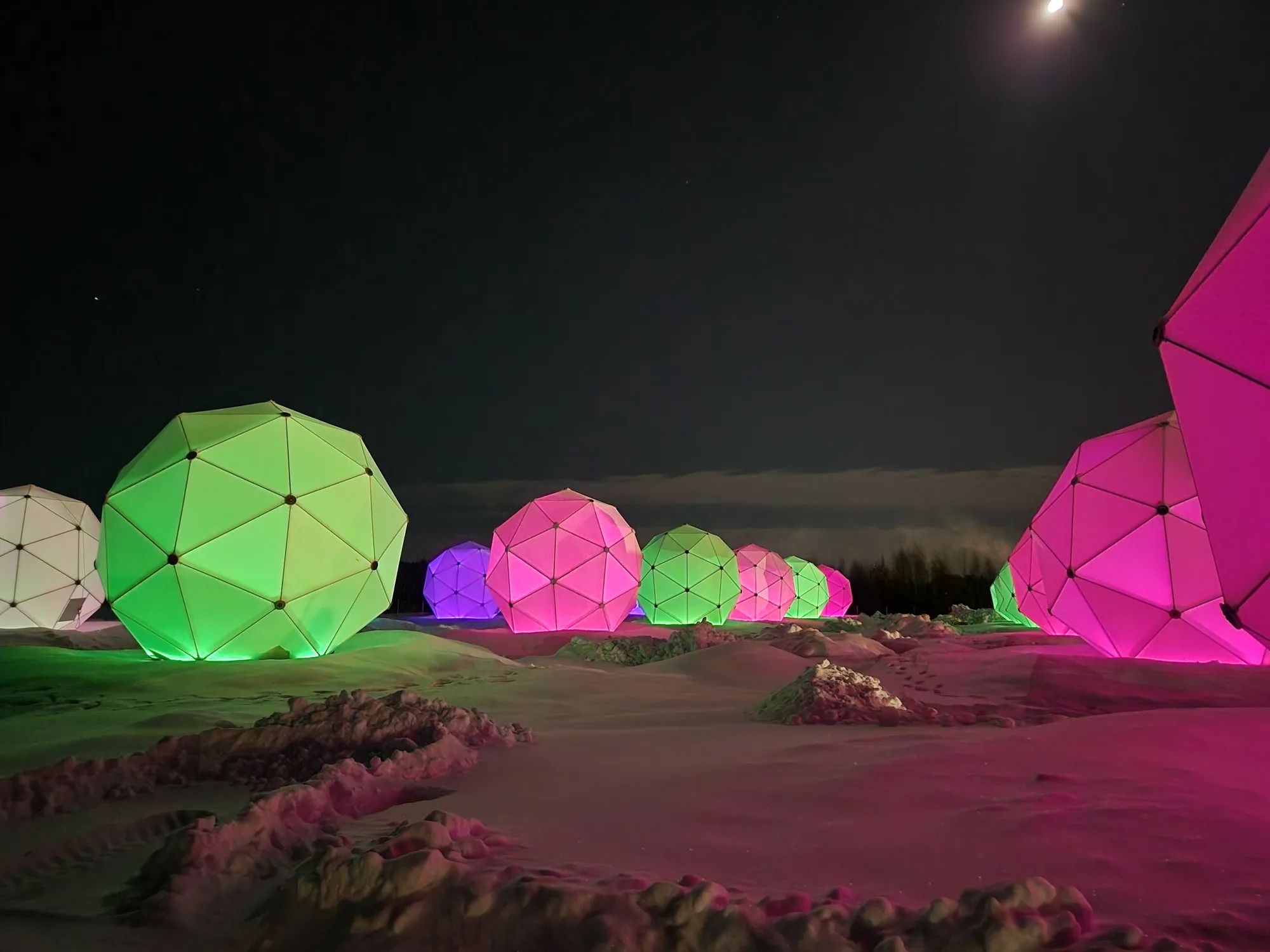 The Arctic Space Center at night, illuminated radomes against the polar sky.